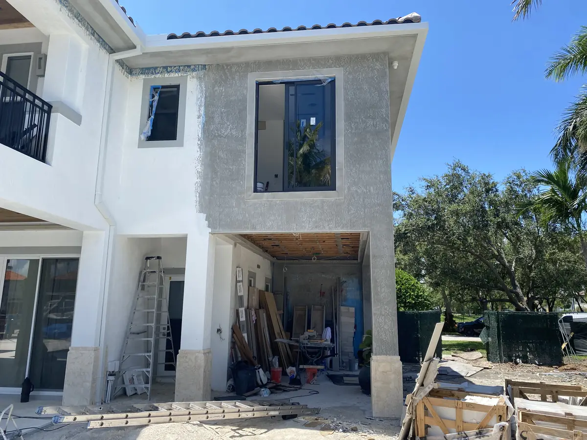 An Oak Park Construction home addition under construction, with an unfinished exterior opening and materials on site.